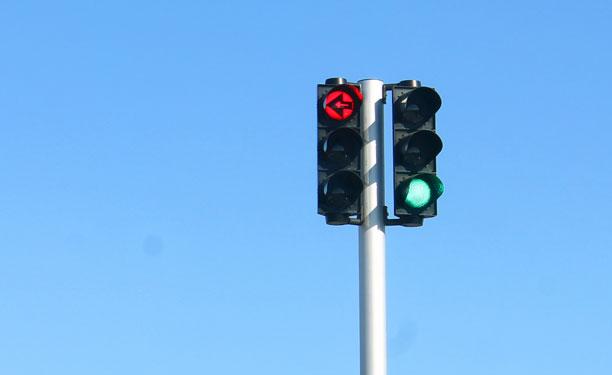 Grønt lys i lysregulering med rød pil til bilisterne i svingbanen.
