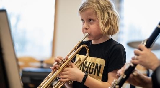 En dreng der spiller trompet