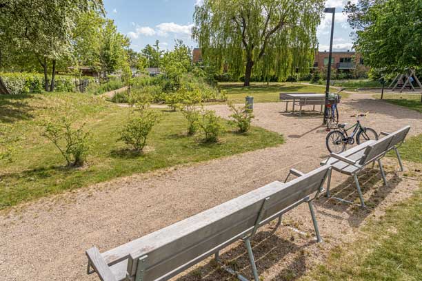 Bænke og picnicborde står ved stier i en grøn park